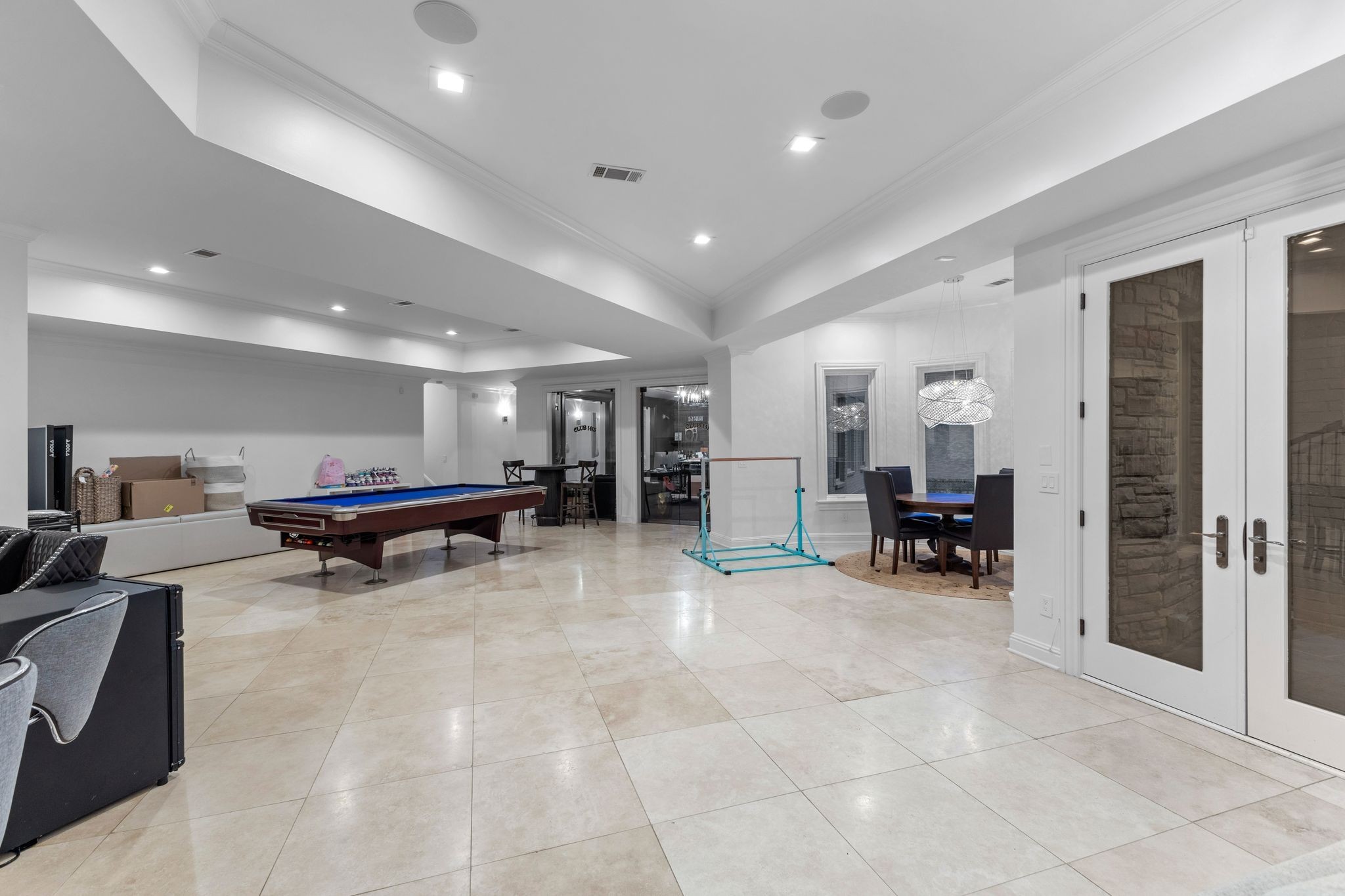 Game room with a blue-felt pool table, tiled floors, and a dining nook.