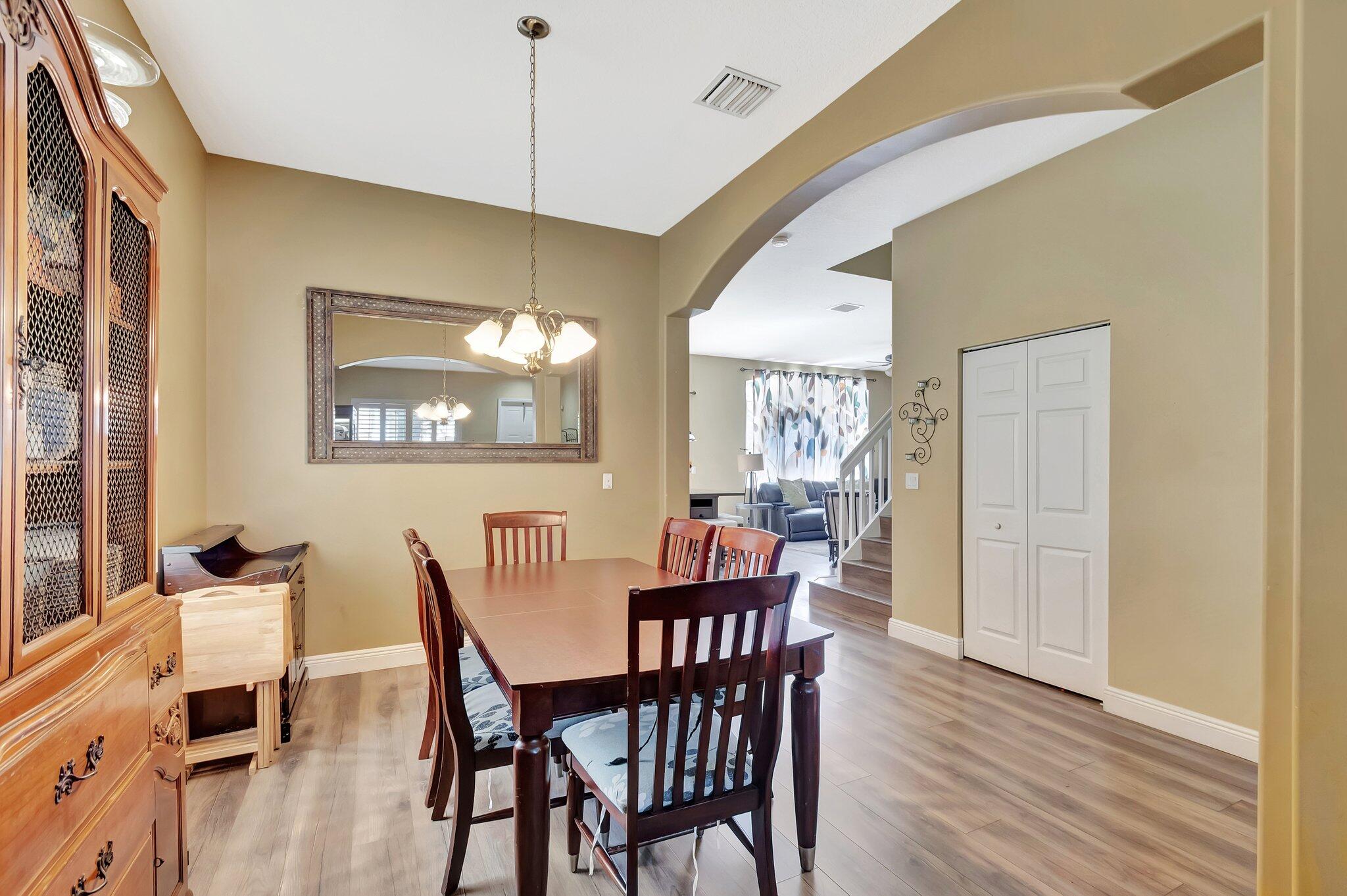 Dining room with a dark wood table, large china cabinet, and arched opening to the living room.