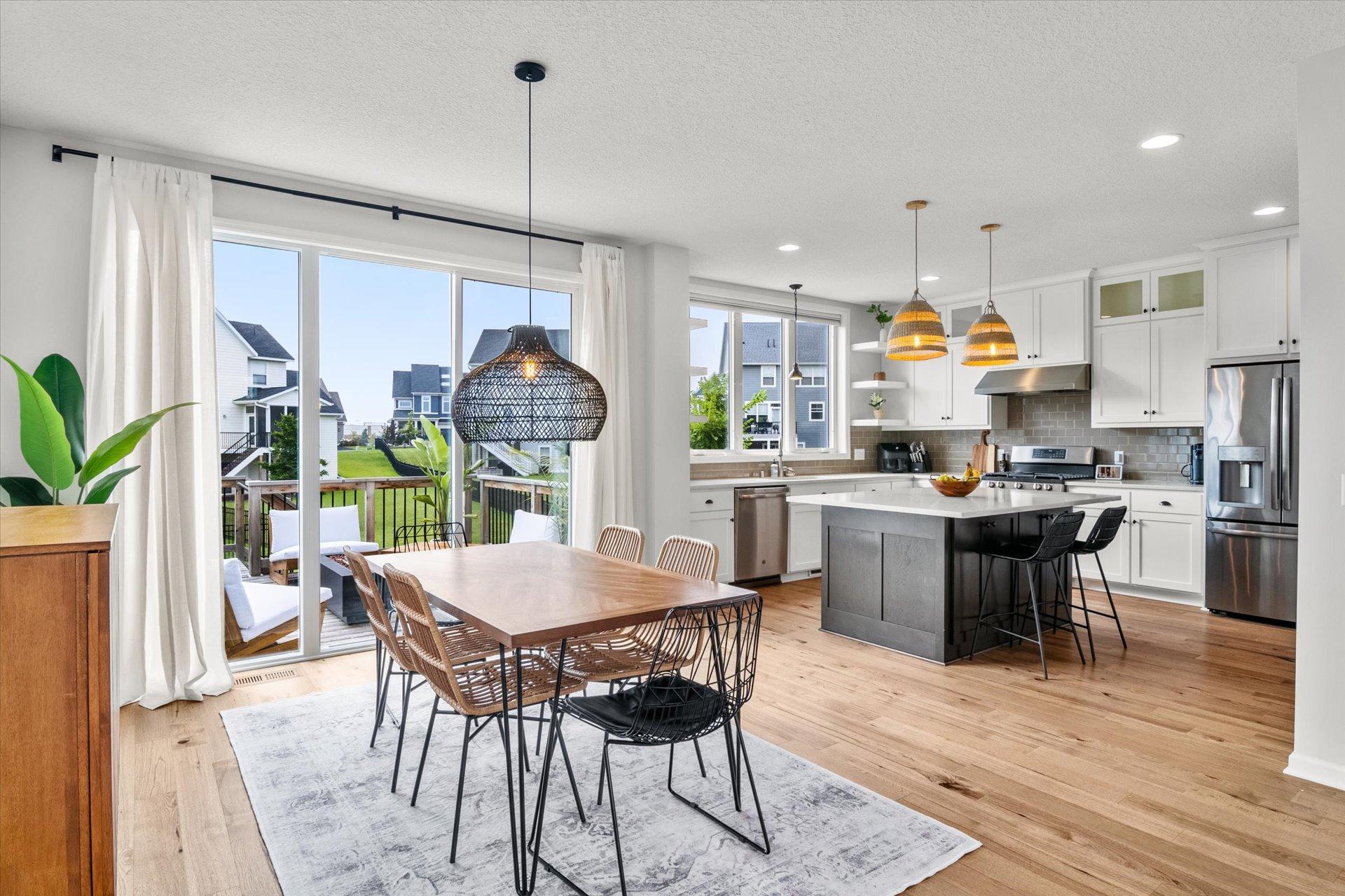 Open-plan kitchen and dining area with a gray island and sliding doors to the deck.