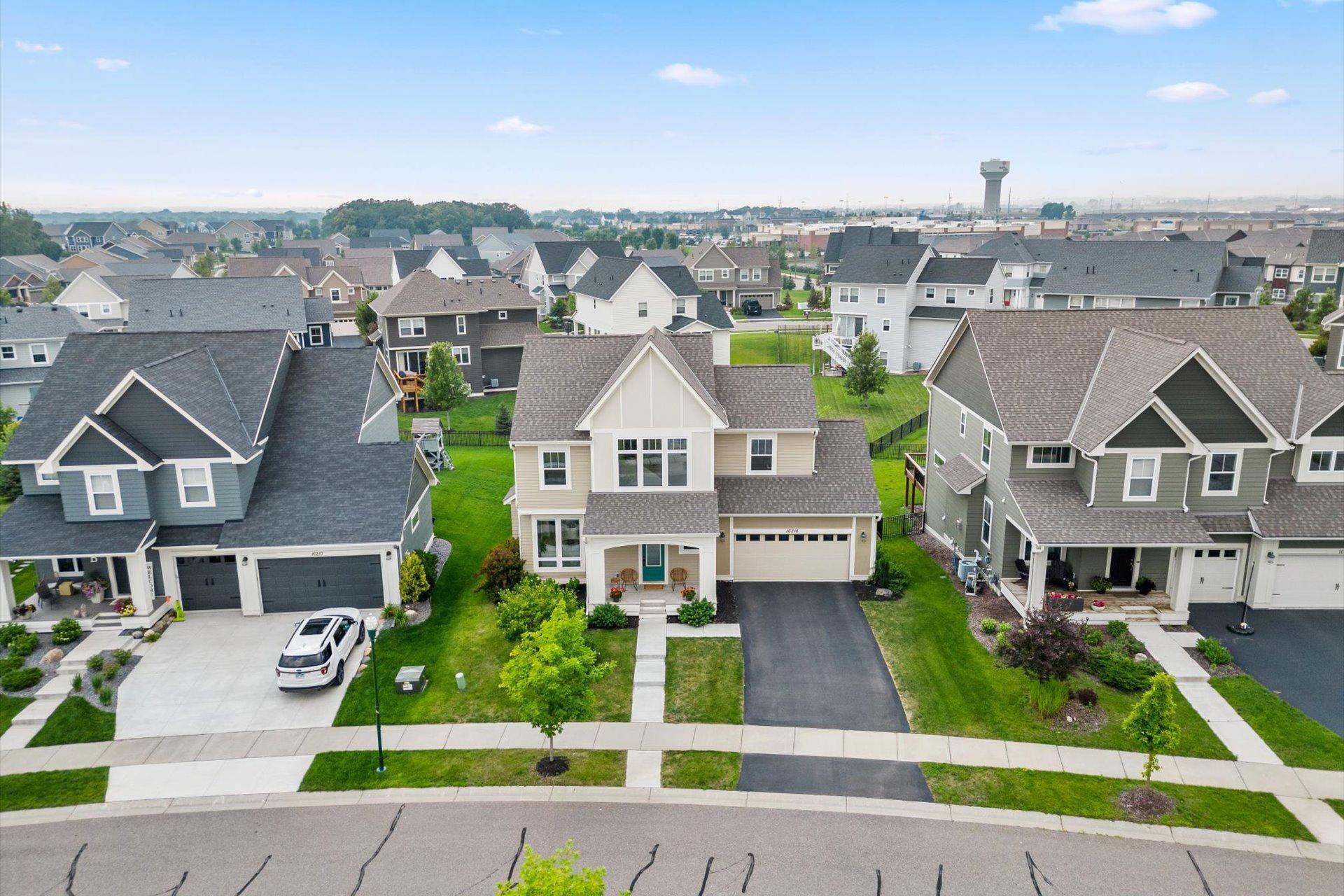 Aerial view of 16214 Elkhorn Trail, a beige two-story home with a front porch and attached garage.