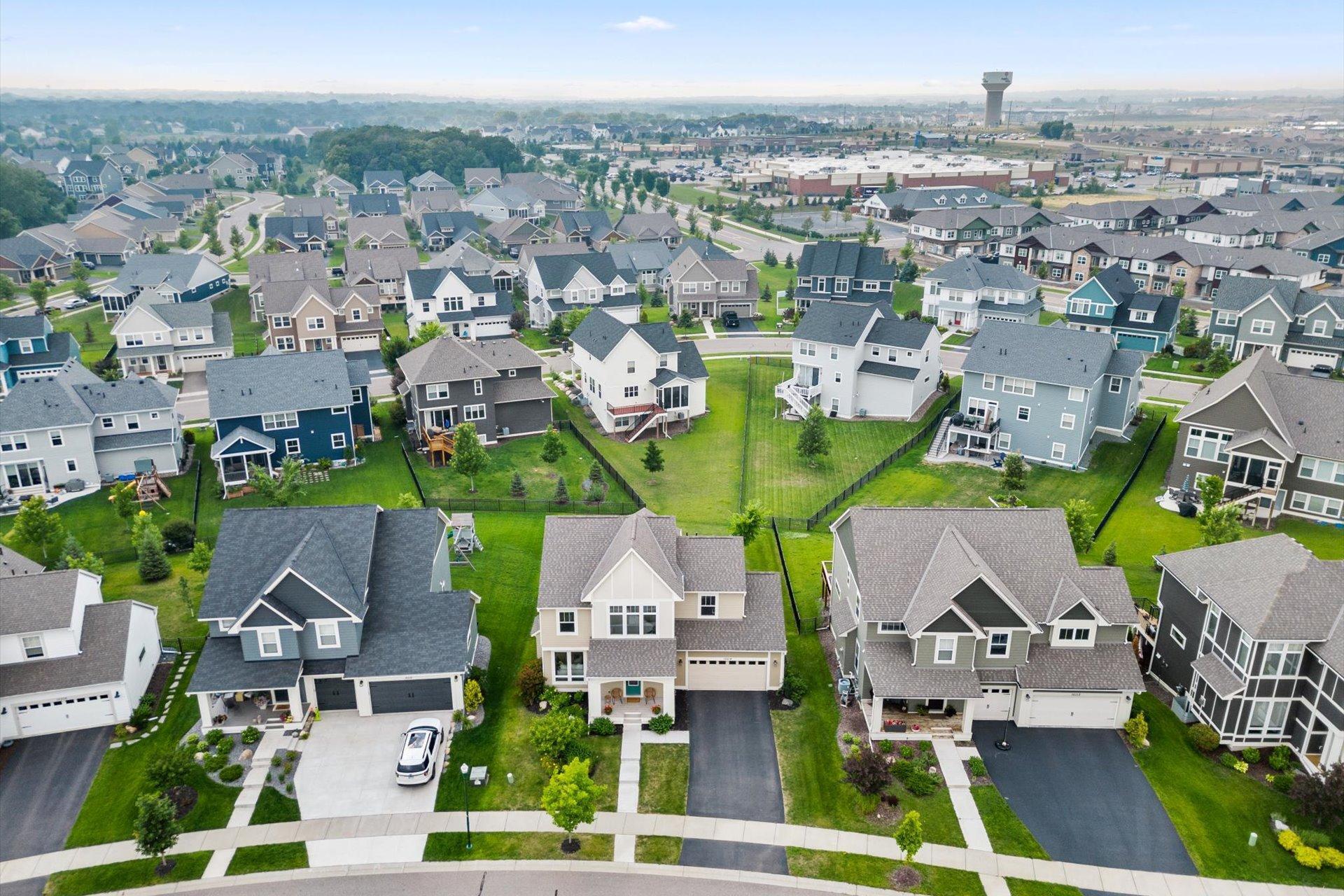 Aerial view of a Lakeville neighborhood with detached homes and a water tower in the distance.