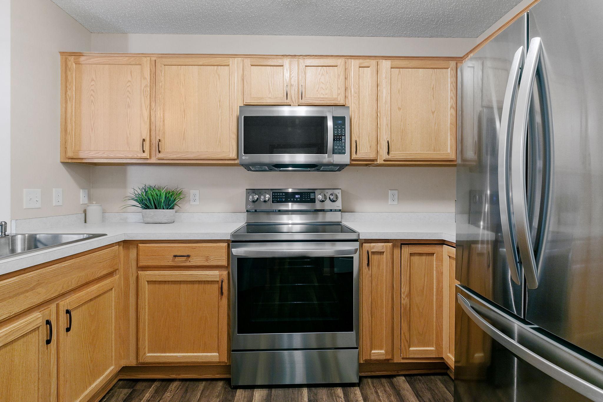 Kitchen with light oak cabinets, stainless-steel appliances, and pale countertops.
