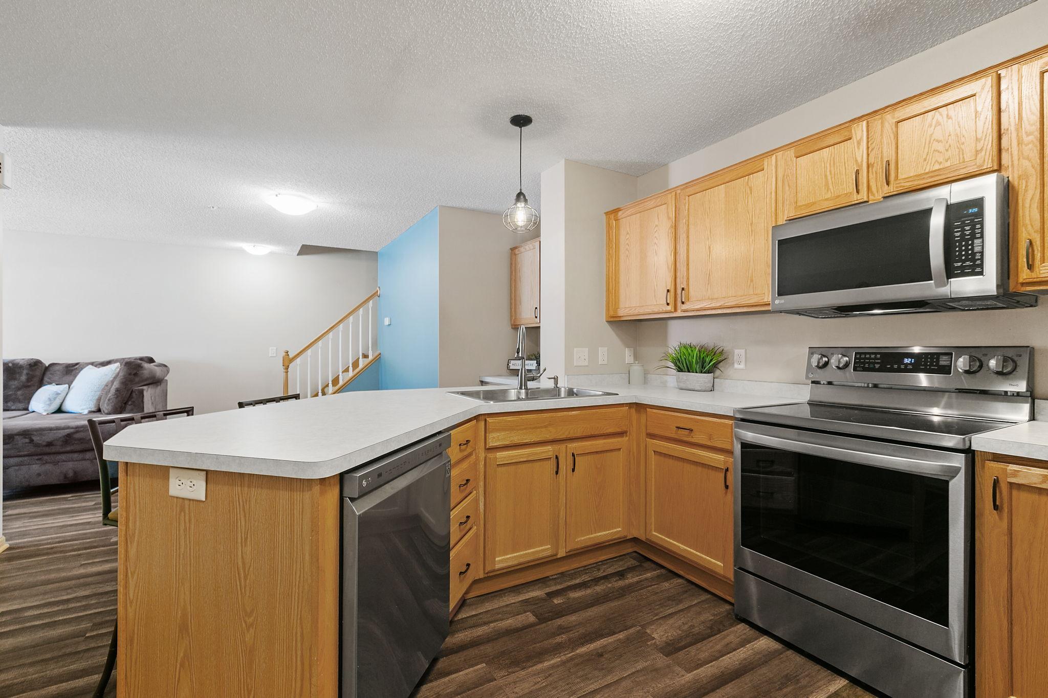 Kitchen with oak cabinets, stainless steel appliances, and a peninsula opening to the living area.
