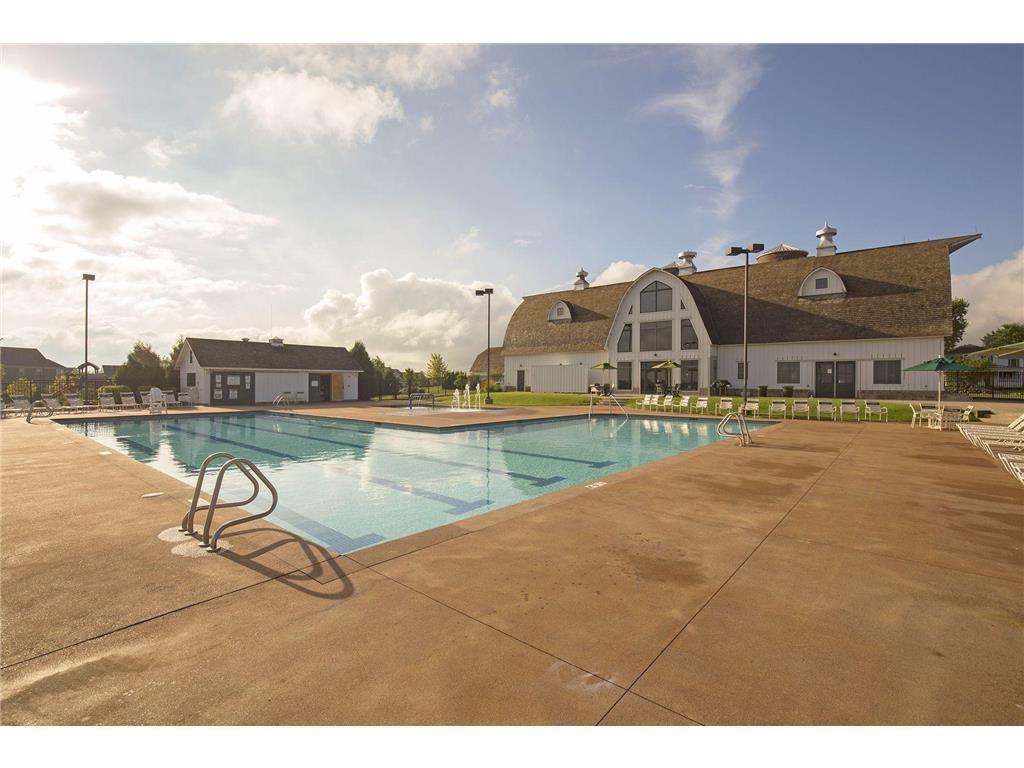 Outdoor pool and deck in front of a large clubhouse with an arched central window.
