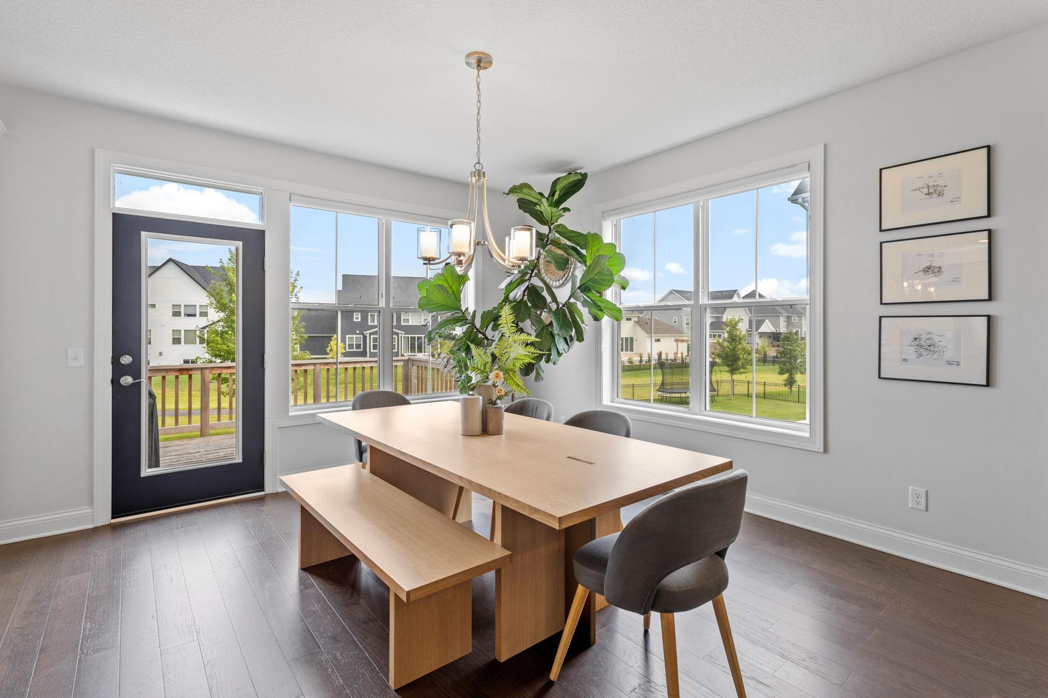 Dining room with a long wood table, large windows, and a glass door to the deck.