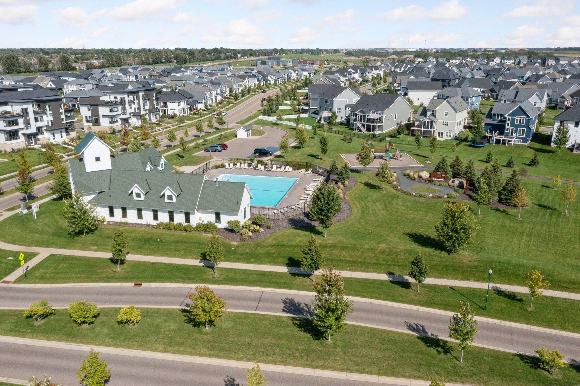 Aerial view of a neighborhood with a community pool, clubhouse, and playground.