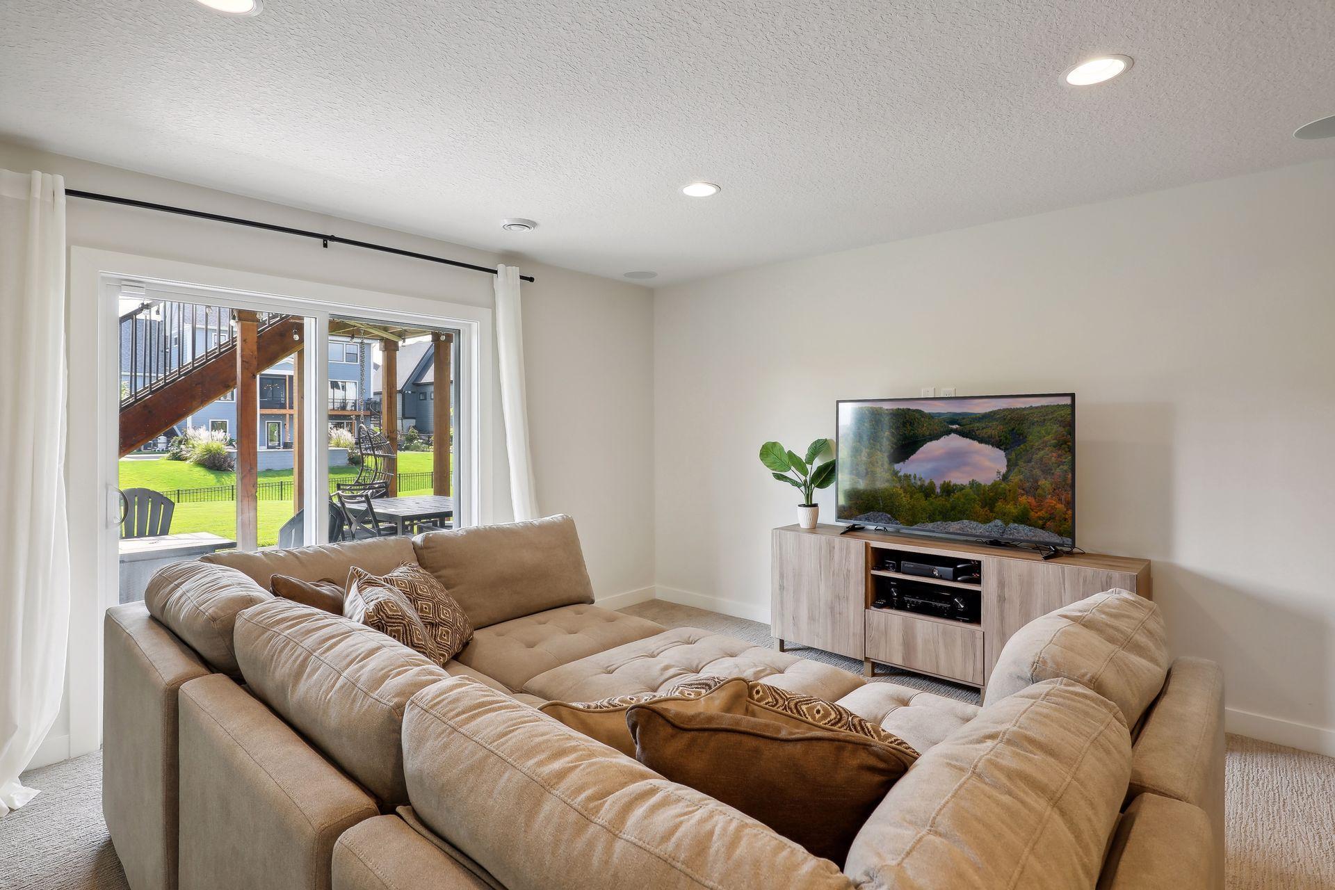 Living room with a beige sectional sofa and sliding doors opening to a covered patio.