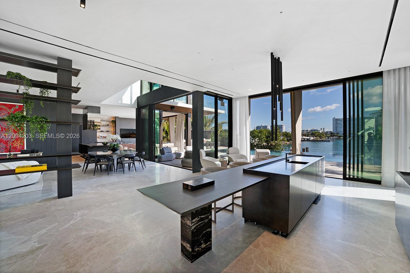 Modern open-plan kitchen with a large island and glass doors overlooking the water.