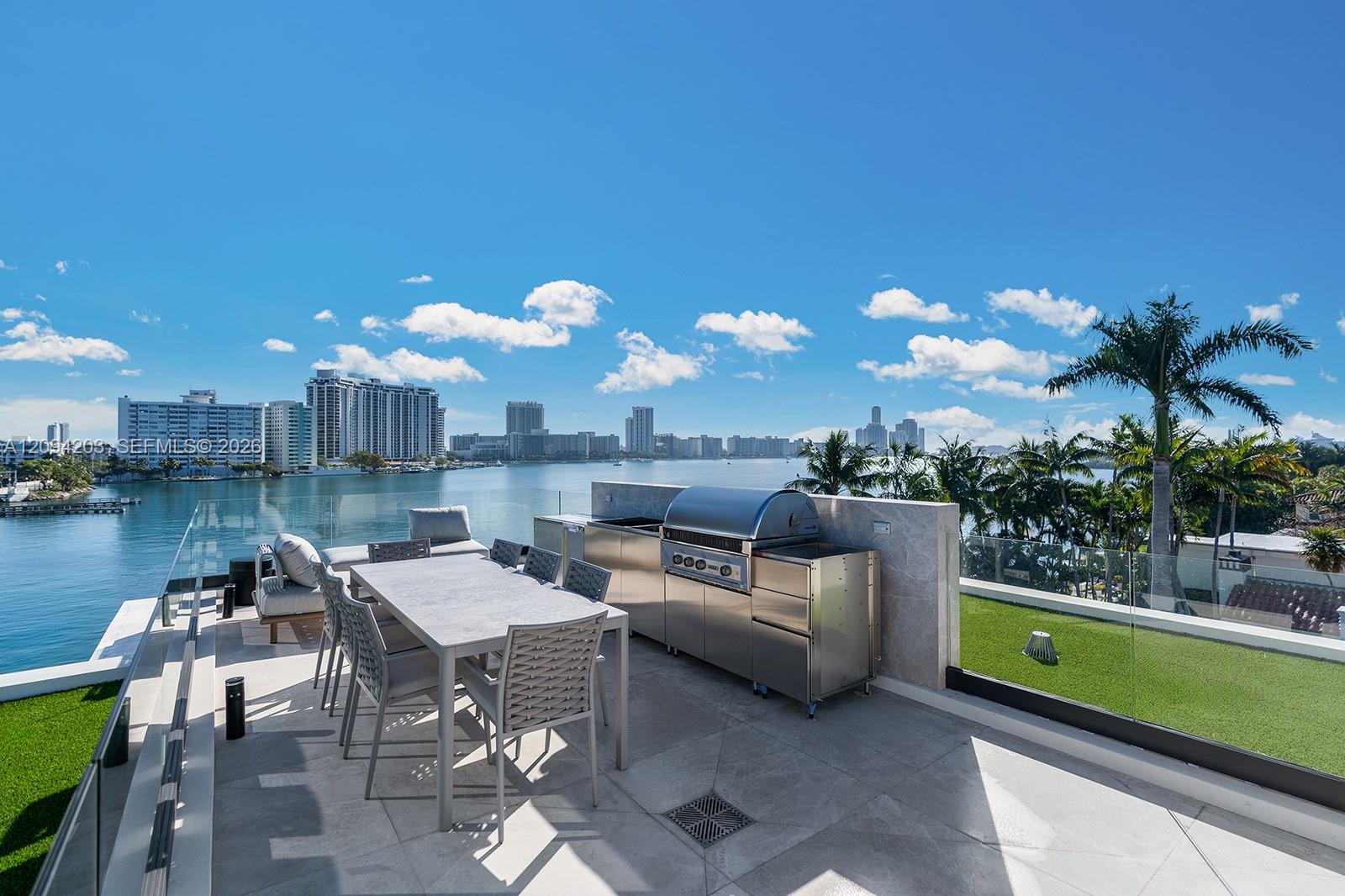 Rooftop terrace with outdoor dining and grill overlooking the water and Miami Beach skyline.