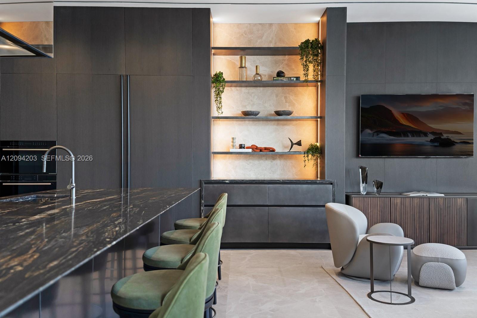 Modern kitchen and living area with a veined stone island and illuminated display shelves.