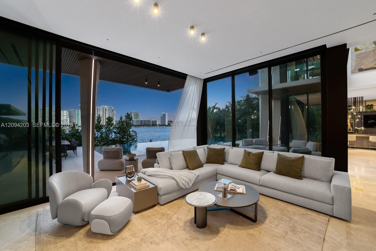 Modern living room with a white sectional, floor-to-ceiling windows, and views of the bay and city.