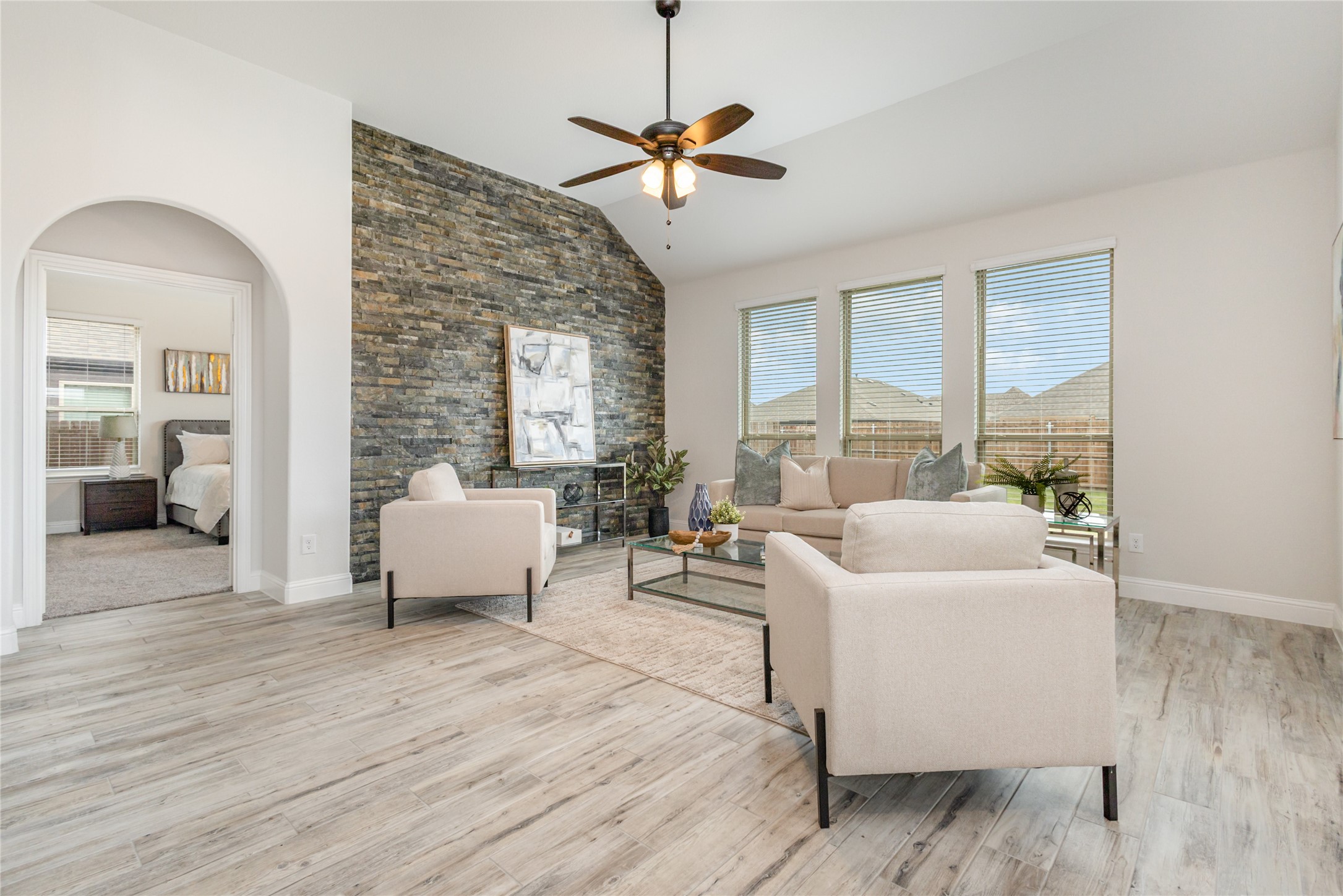 Family room with vaulted ceiling and stacked stone accent wall &mdash; 4130 Lagoon Place Waterscape Royse City TX