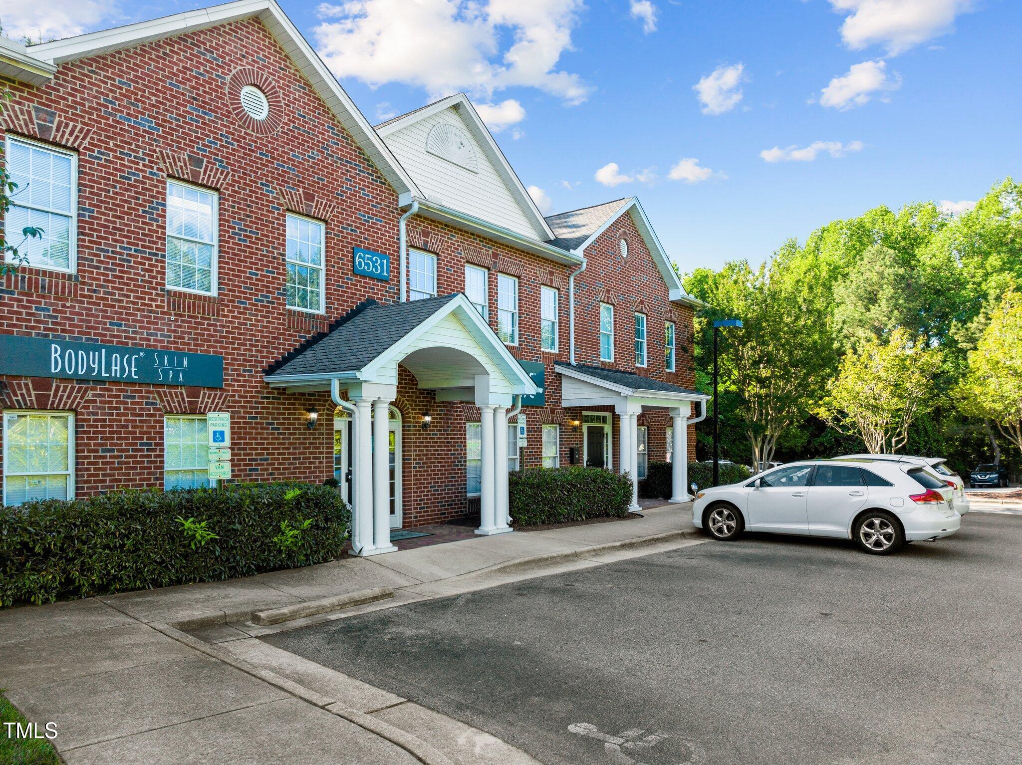 Red-brick commercial building with white entrance canopies and a Bodylase Skin Spa sign.