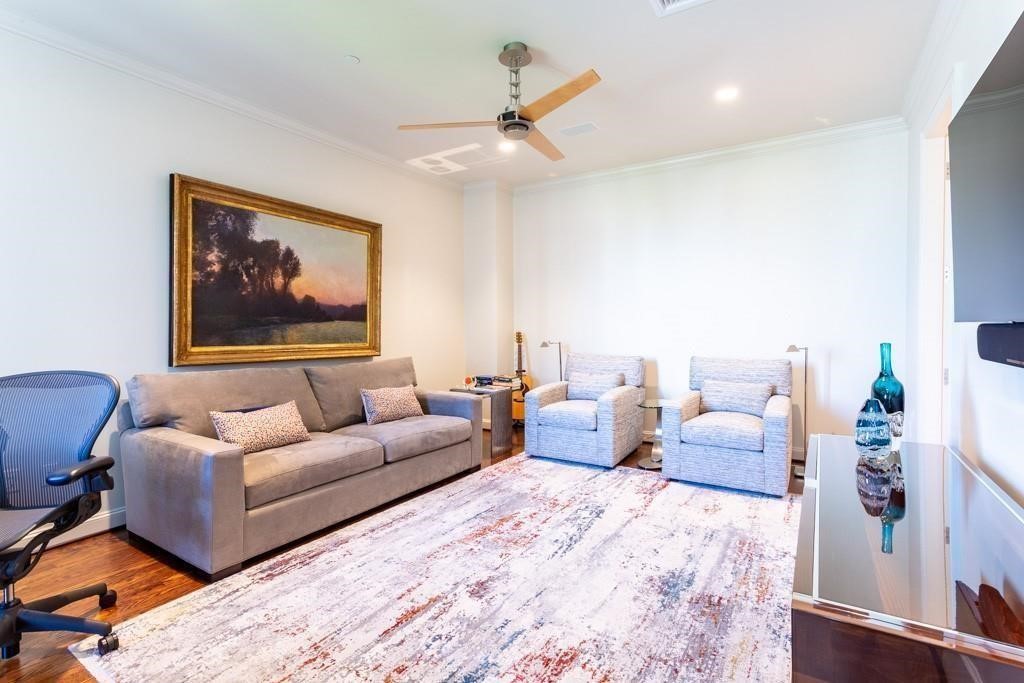 Furnished living room with a gray sofa, two armchairs, and a large patterned rug.