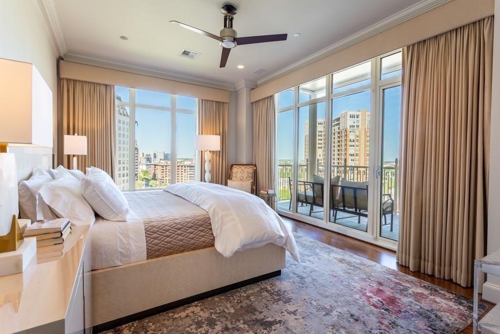 High-rise bedroom with a large bed and floor-to-ceiling windows overlooking the city.