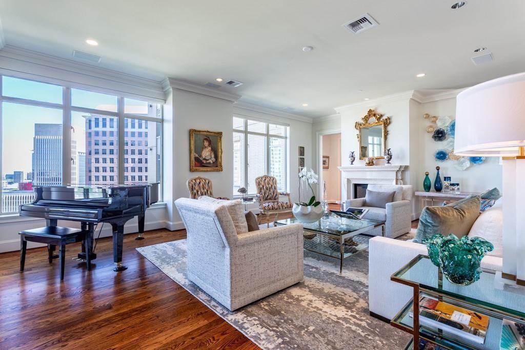 High-rise living room with a grand piano, fireplace, and city views through large windows.