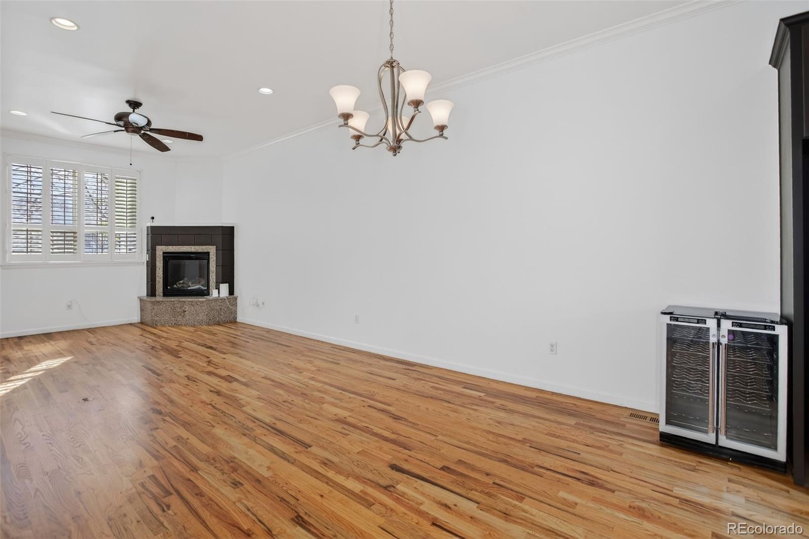 Unfurnished living room with hardwood floors, a gas fireplace, and a built-in wine refrigerator.