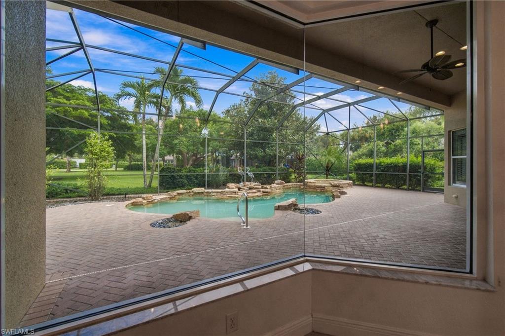 Screened pool lanai with brick pavers and tropical landscaping.