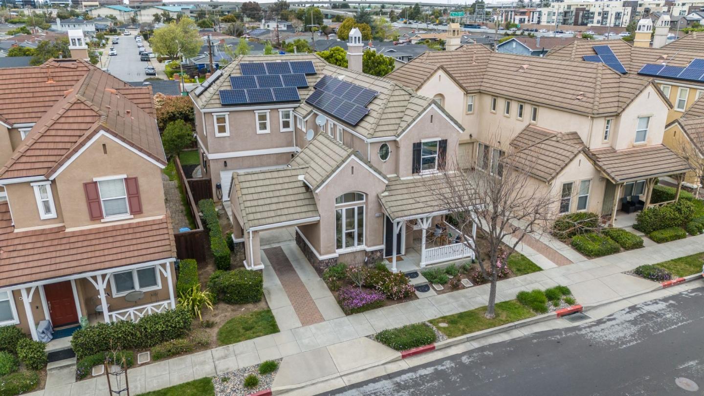 Aerial view of attached homes, with solar panels visible on several tiled roofs.