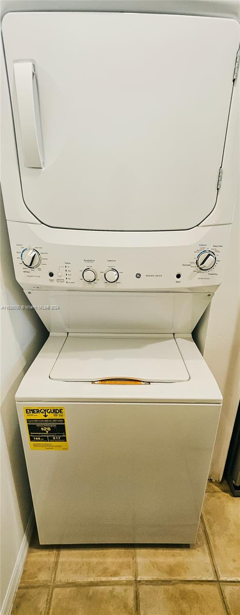 Stacked white washer and dryer in a narrow laundry closet, with an EnergyGuide label on the lower machine.