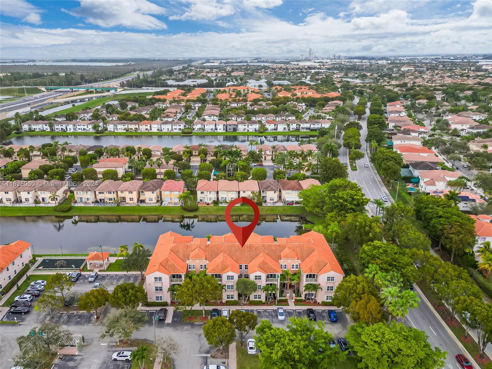 Aerial view of the marked residential complex beside a canal, surrounded by homes and roads.