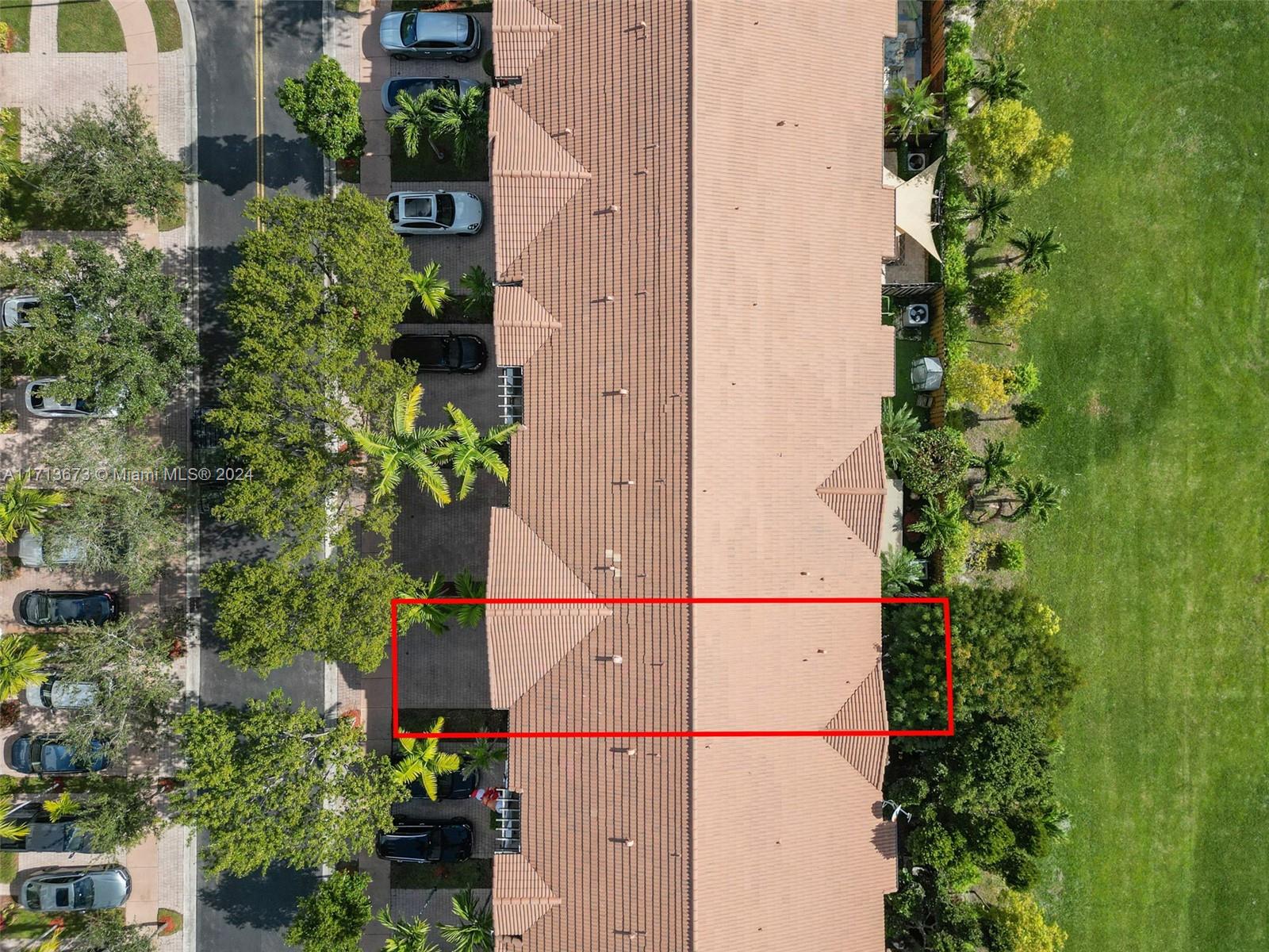 Aerial view of attached homes, with one terracotta-roofed unit outlined in red.