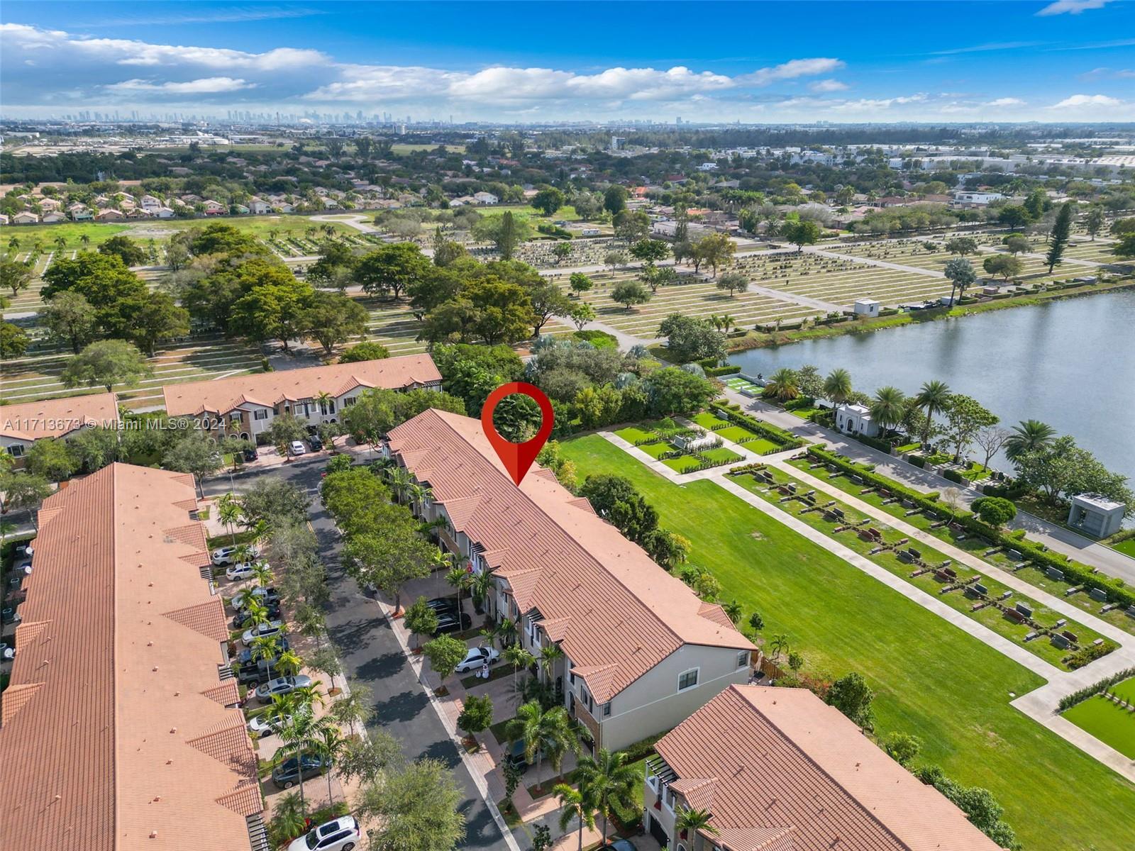 Aerial view of a townhouse marked in red beside a cemetery and waterfront.