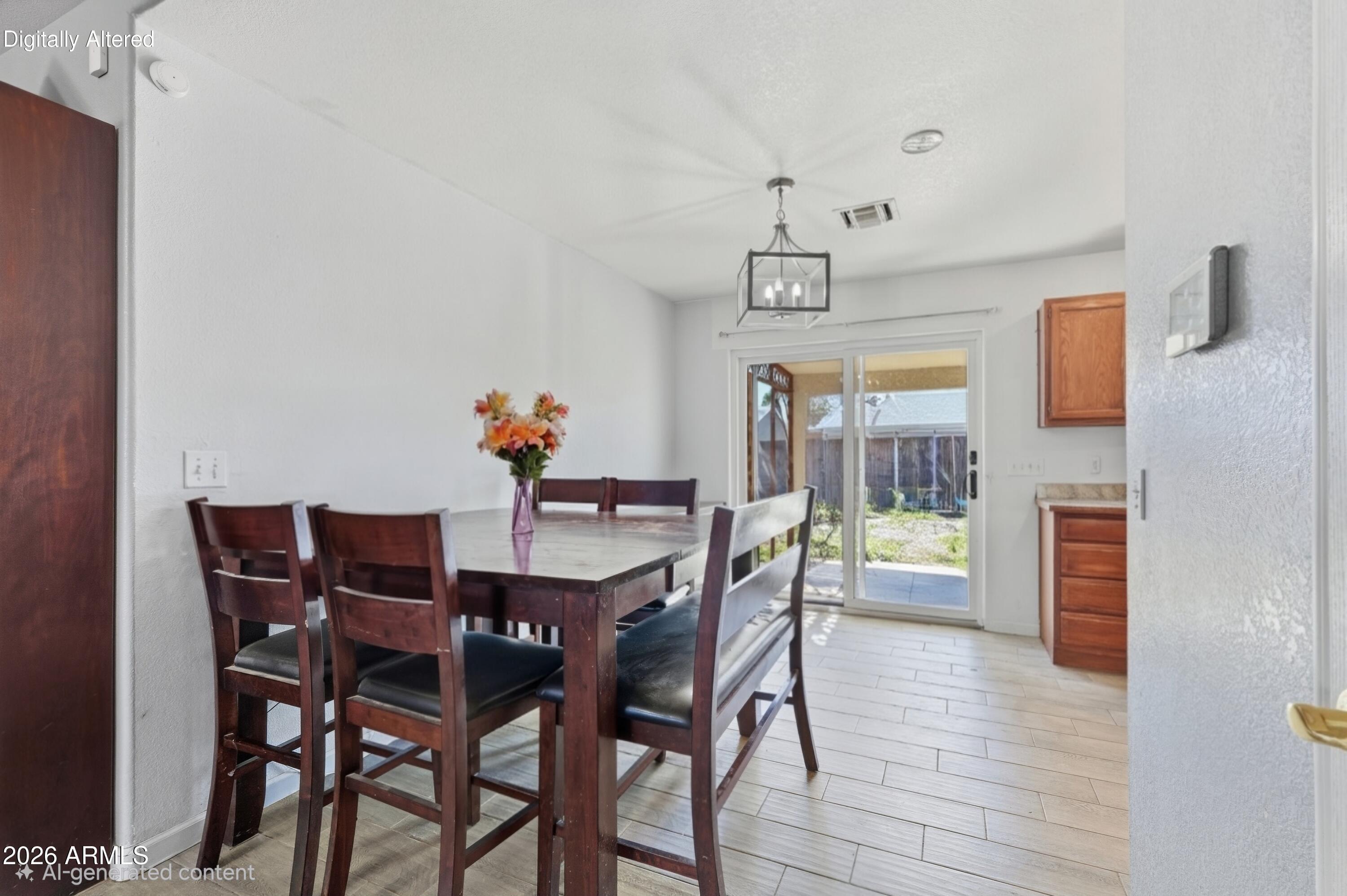 Dining area with a dark wood table and chairs beside a sliding glass door to the yard.