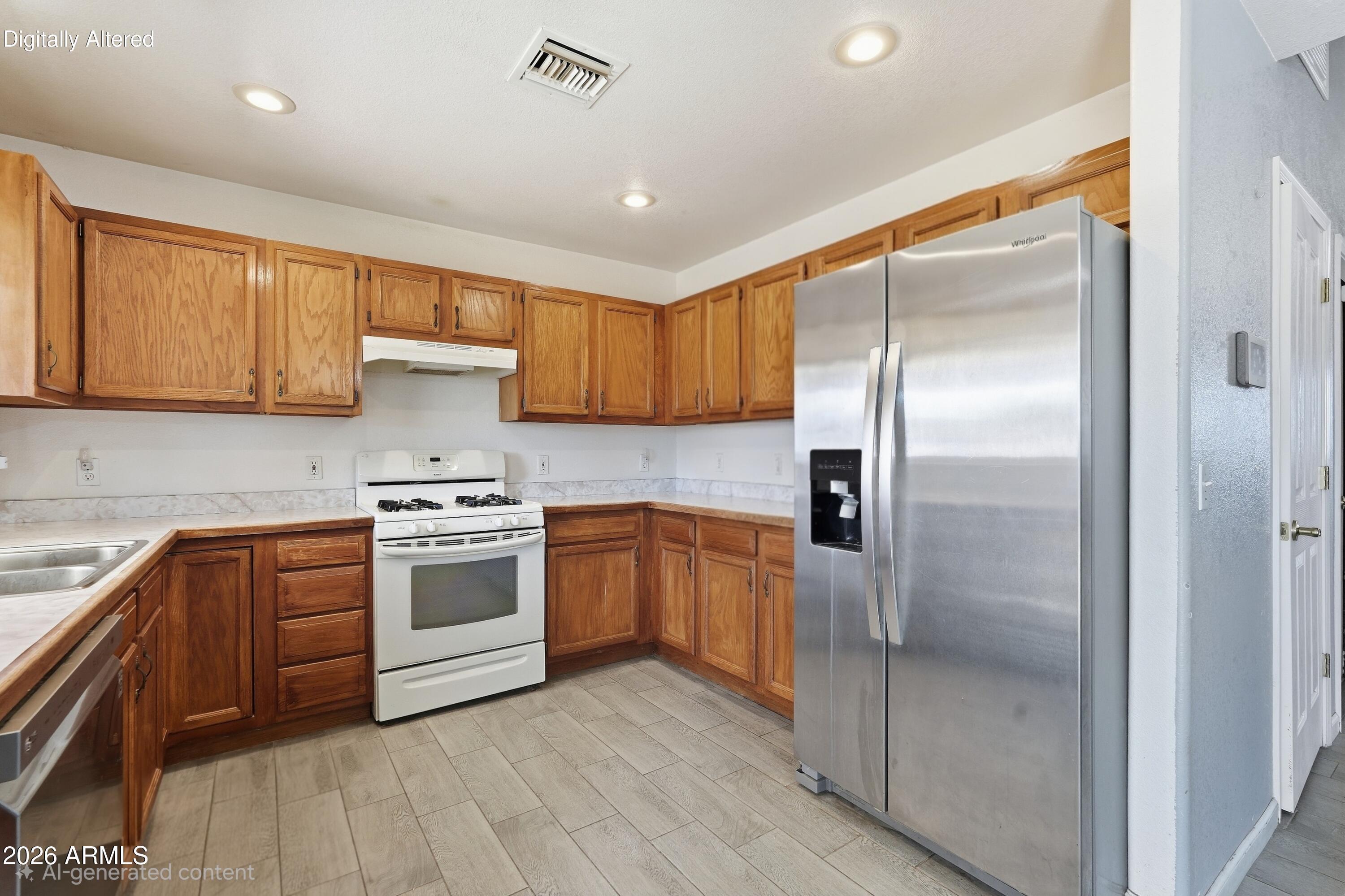 Kitchen with wood cabinets, a white gas range, and a large stainless steel refrigerator.