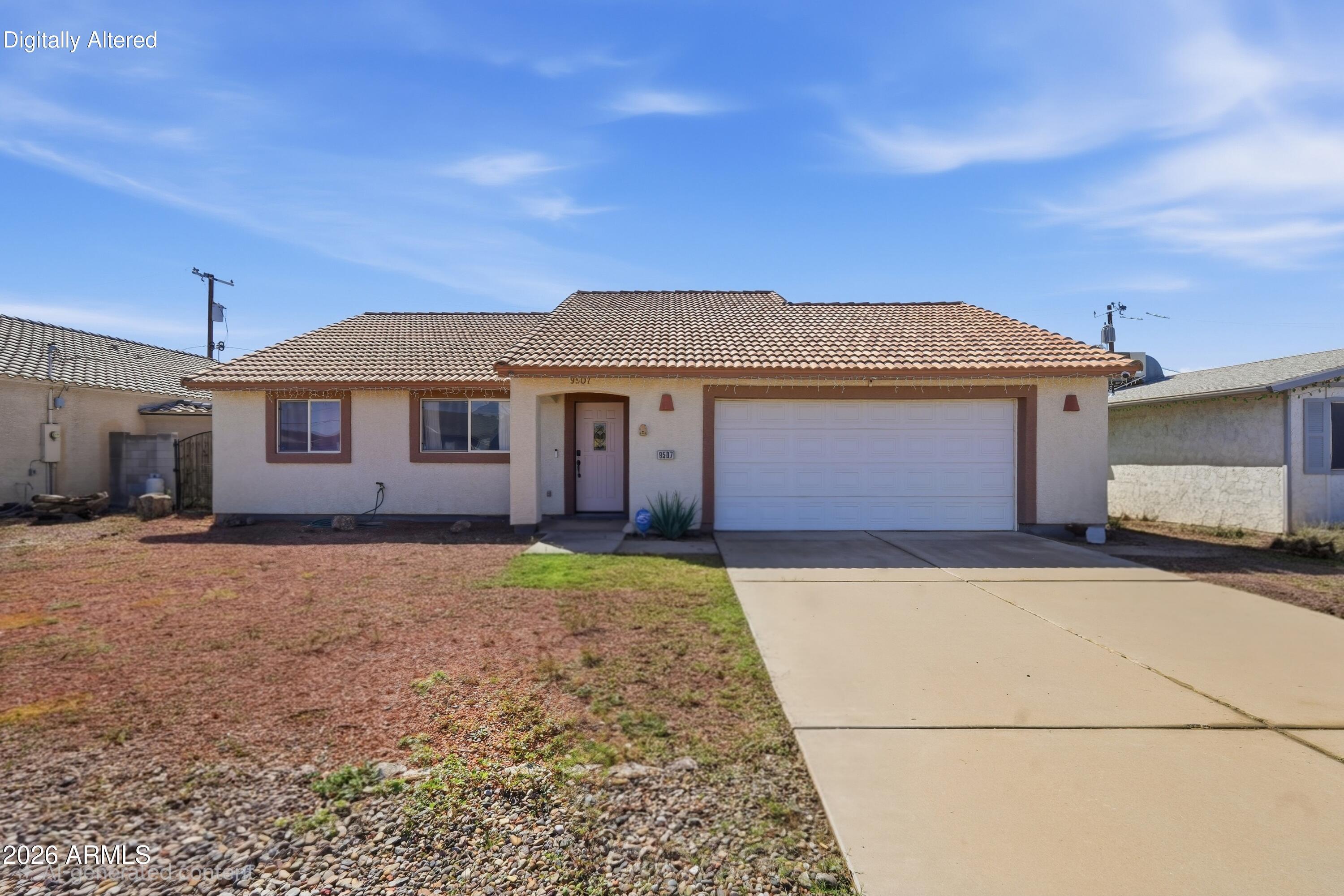 Single-story stucco home with a tiled roof, two-car garage, and gravel front yard.