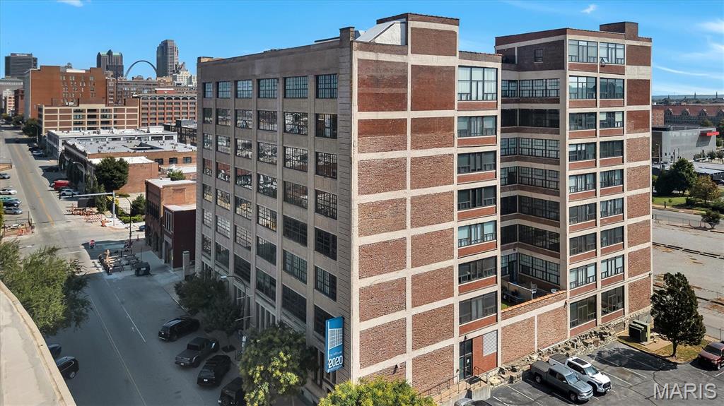Multi-story brick building with large industrial windows and the St. Louis skyline behind it.