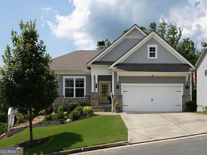 Gray gabled house with stone accents, a front lawn, and a two-car garage.