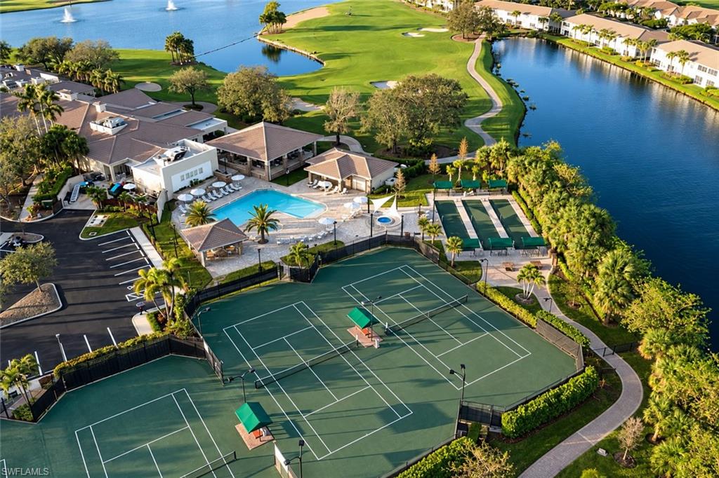 Aerial view of community tennis courts, pool, clubhouse, golf course, and lakes.