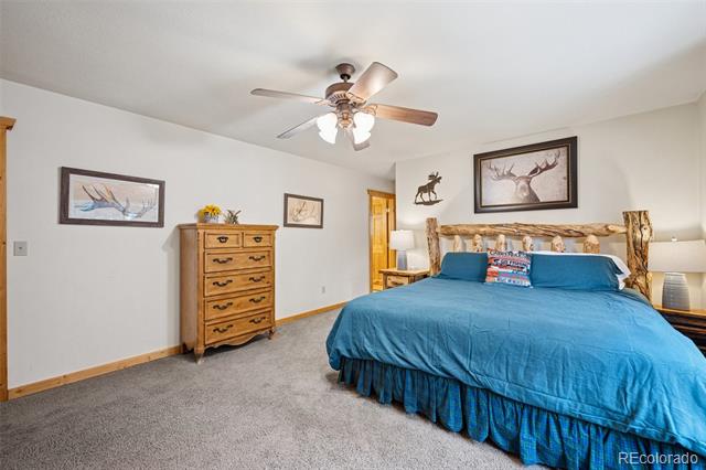 Bedroom with bright blue bedding, a rustic log headboard, and wildlife artwork.