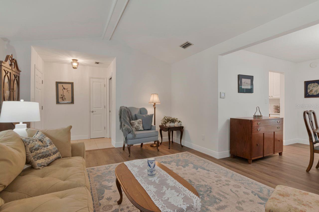 Living room with a beige sofa, blue accent chair, and patterned rug.