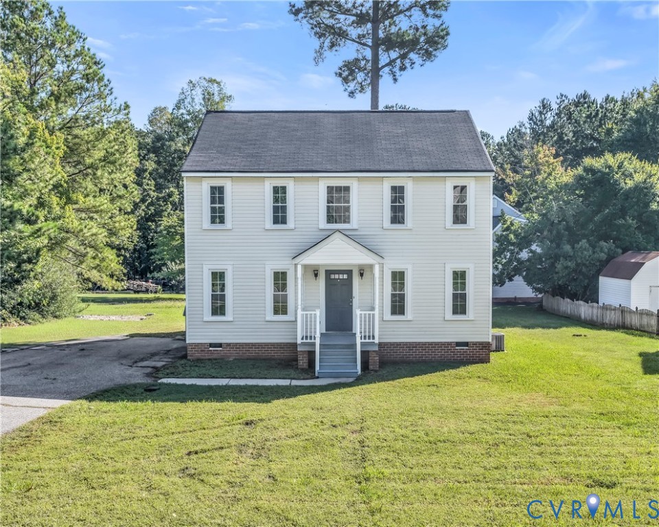 White two-story home with a centered entrance, small porch, and broad grassy front yard.
