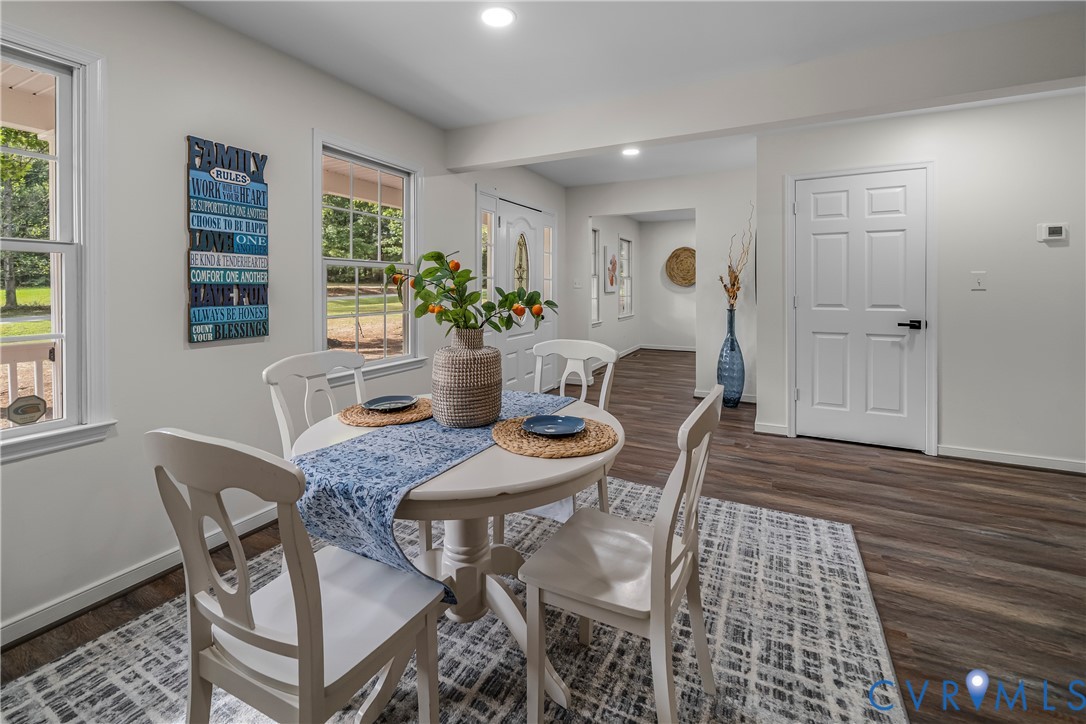 Staged dining room with a white round table, blue runner, and large windows.