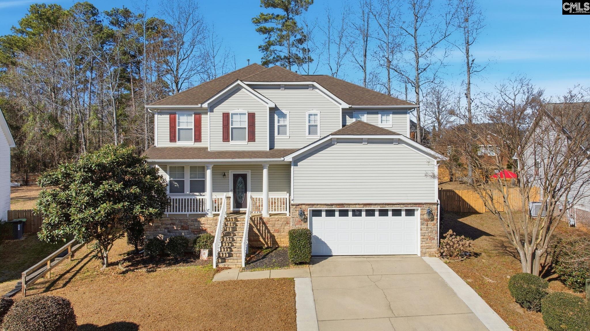 Two-story gray house with red shutters, a covered porch, and an attached two-car garage.