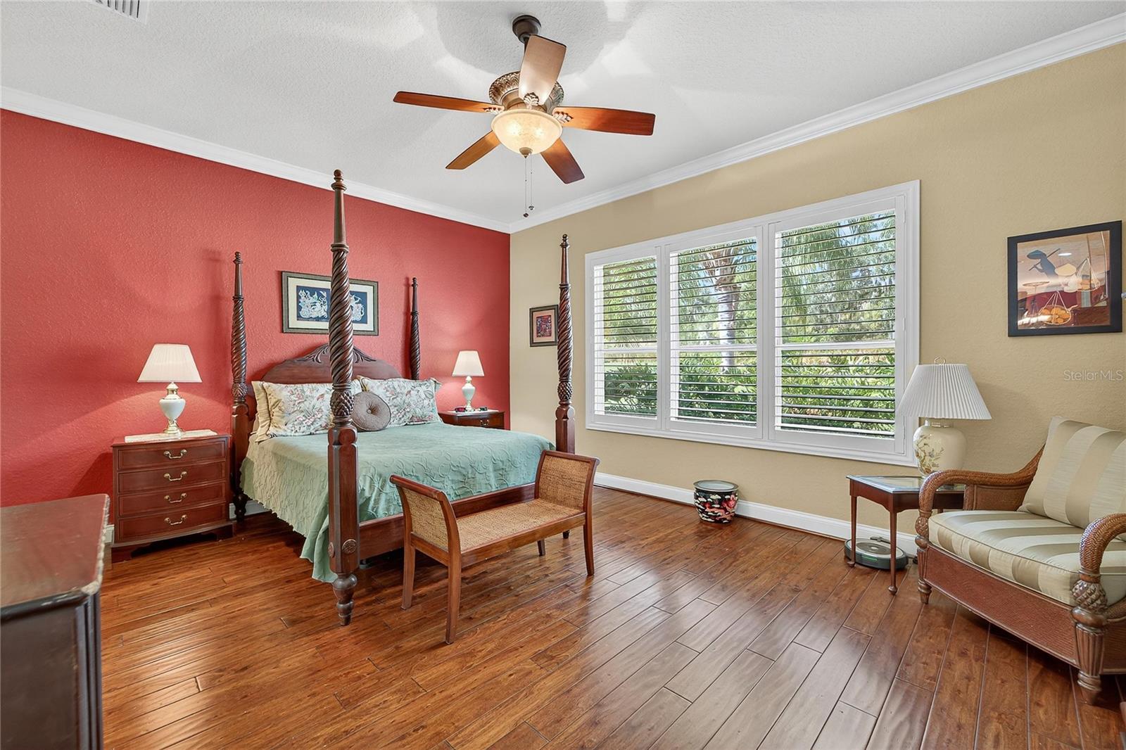 Primary bedroom with hardwood floors and natural light