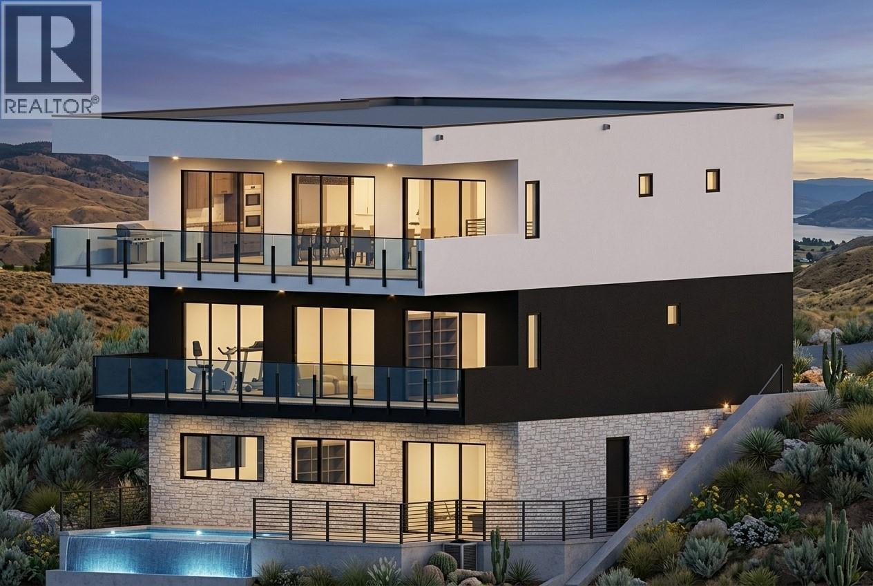 Modern three-level home with glass balconies and a pool, set against hills and a lake at dusk.