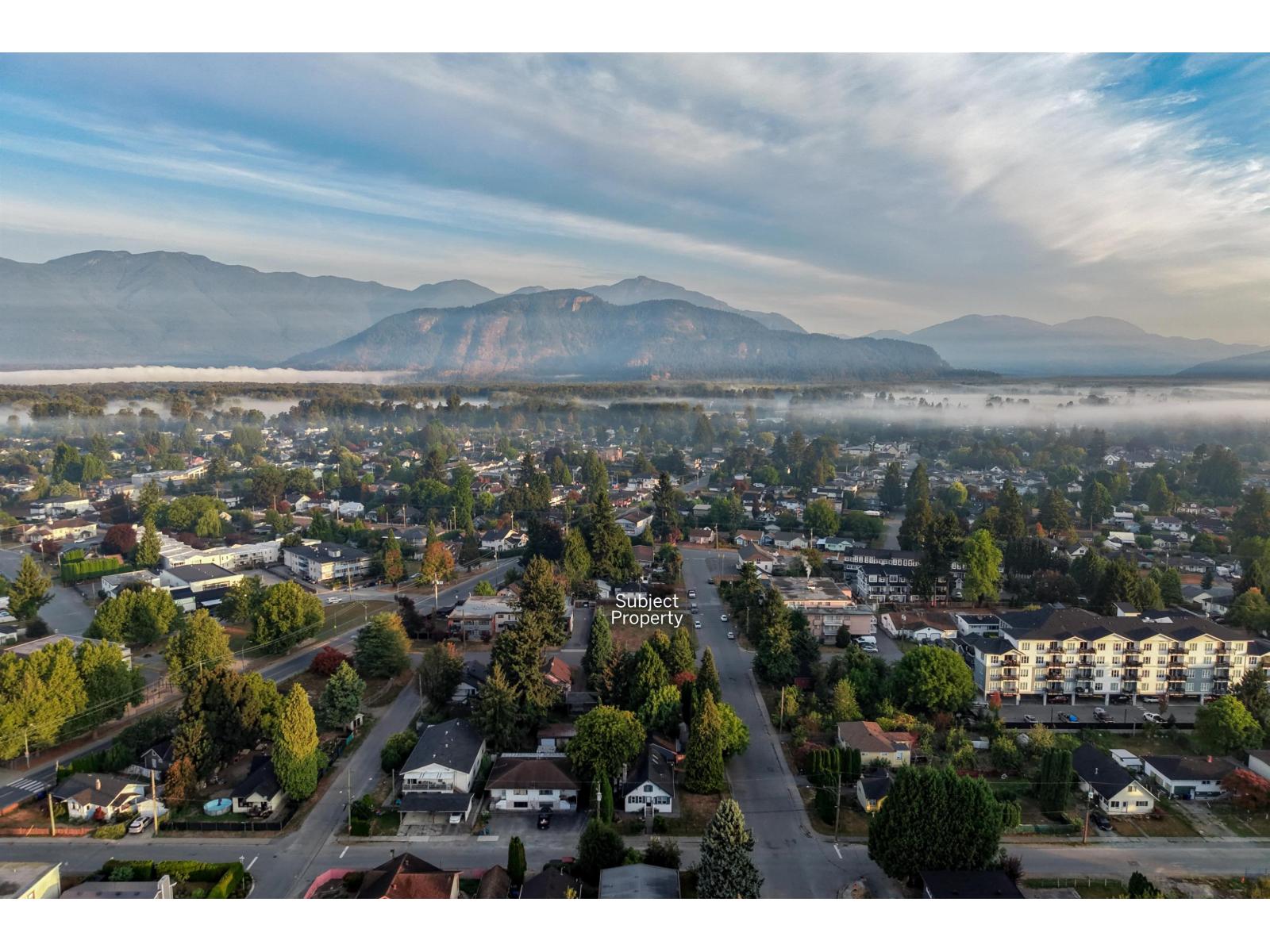 Aerial view of the neighborhood, with the subject property marked and mountains beyond.