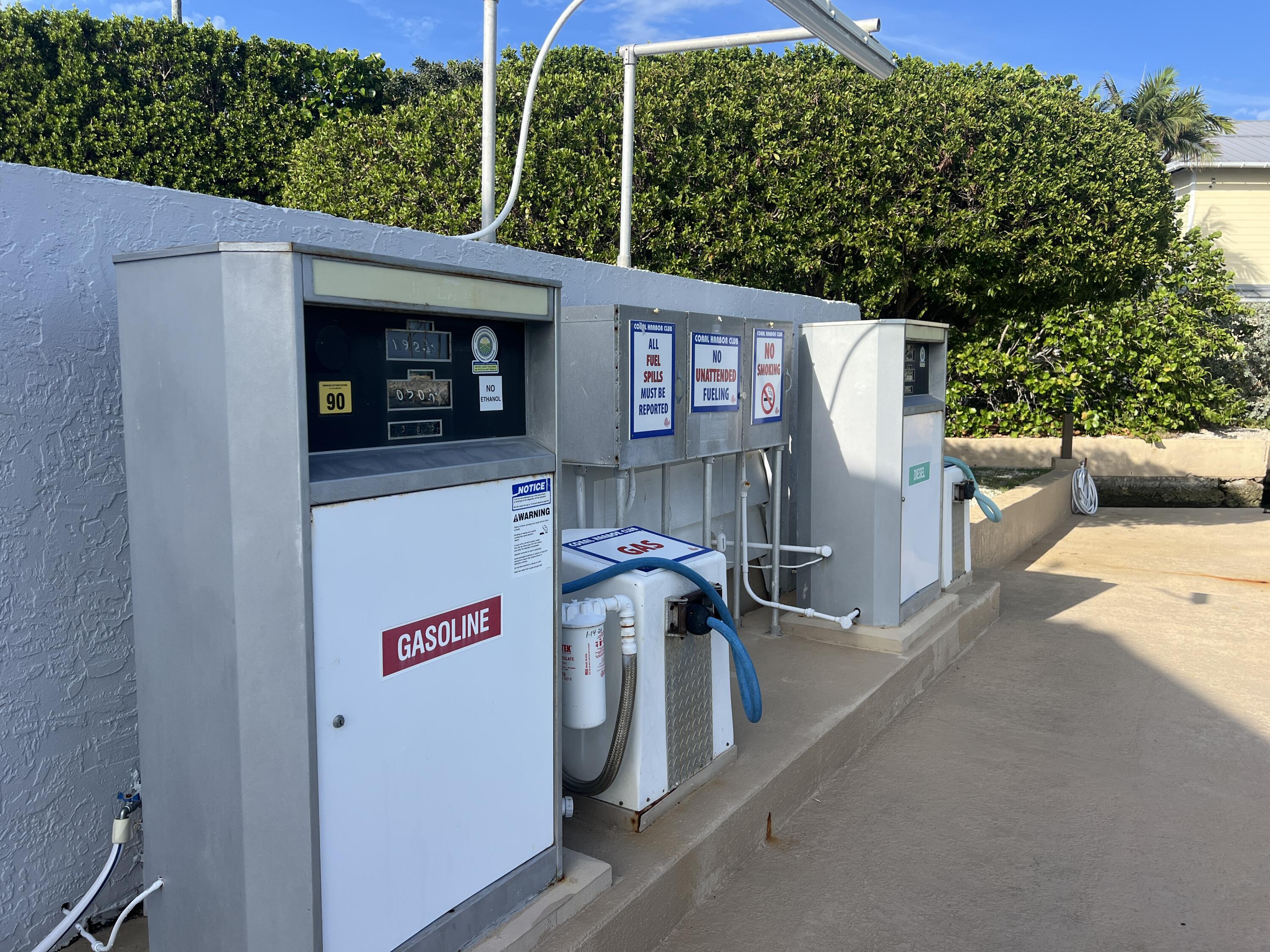 Outdoor fuel pumps with gasoline and diesel dispensers, hoses, and safety signs.