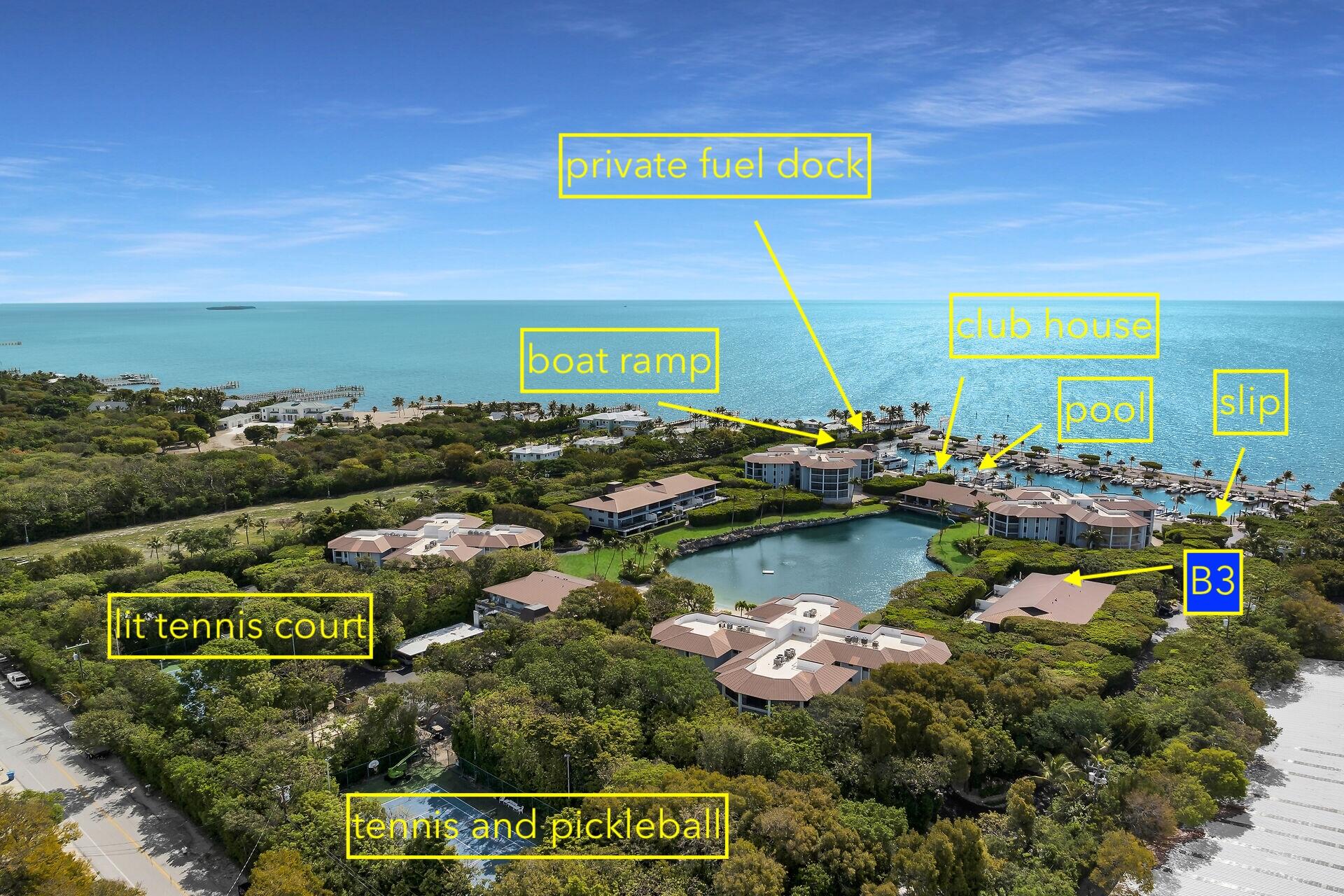 Aerial view of waterfront community B3, with ocean, marina, pool, and tennis courts.