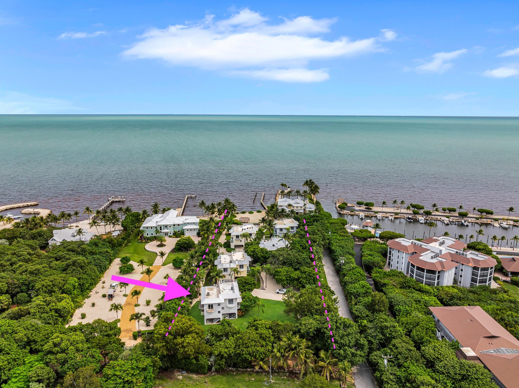 Aerial view of the oceanfront property, outlined in magenta beside a marina.