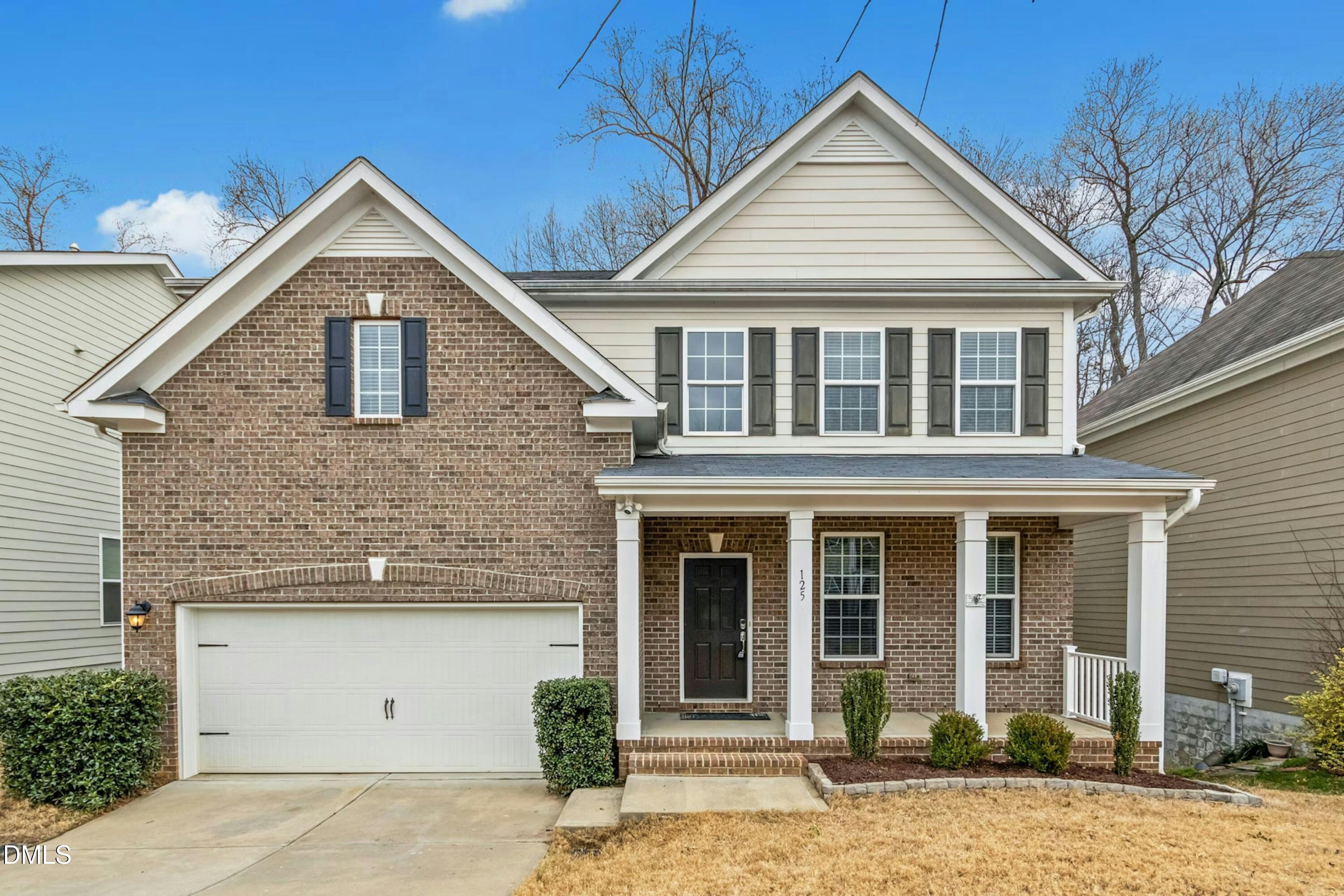 125 Spring Pine Lane home with brick facade, two-car garage, and covered front porch.