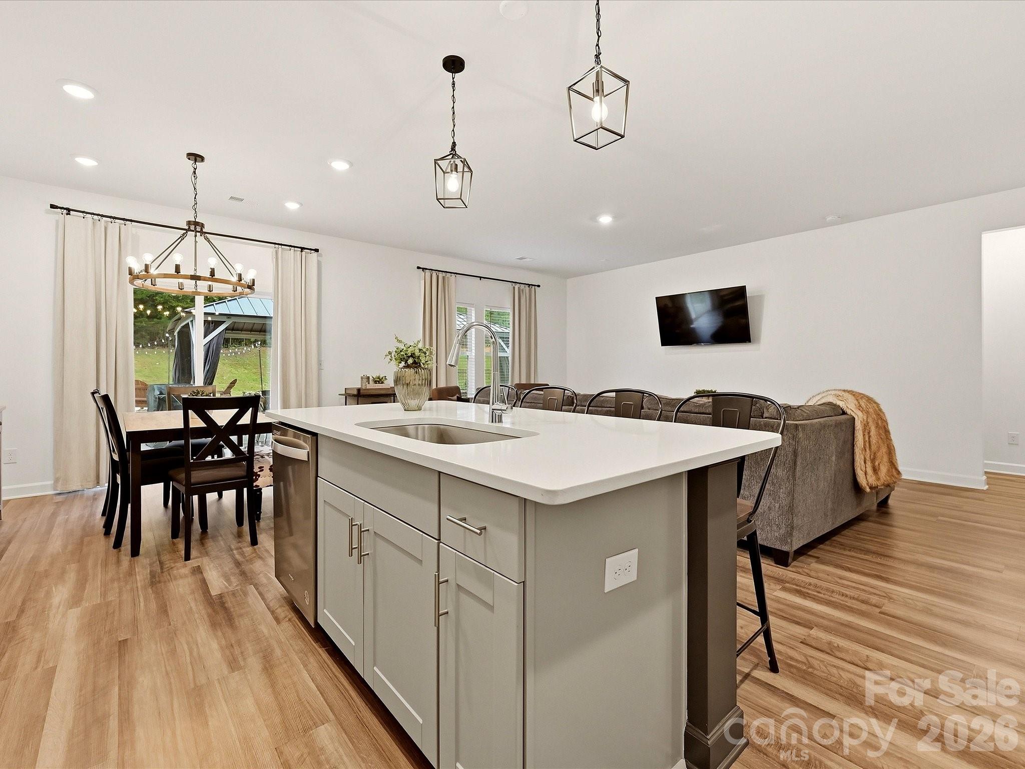 Open-plan kitchen with a large white island, dining table, and living area.