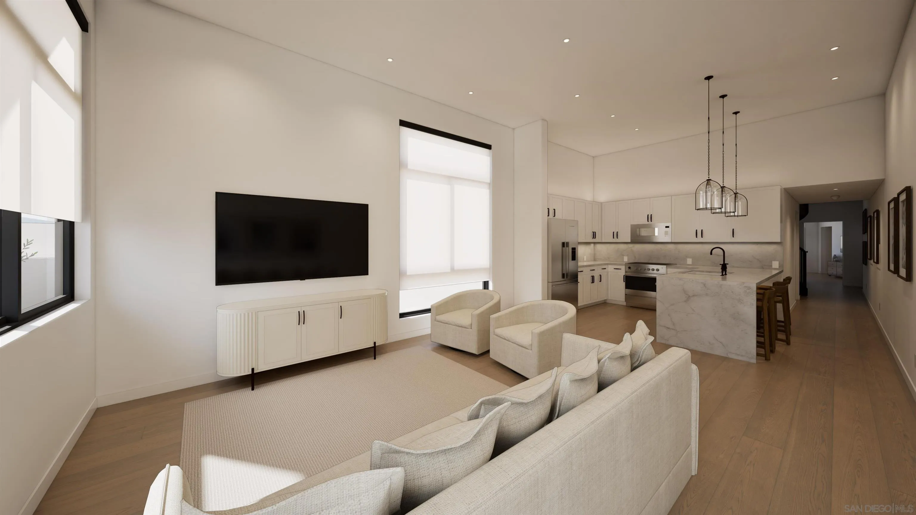 Open-plan living room and kitchen with a white sectional, marble island, and tall shaded windows.