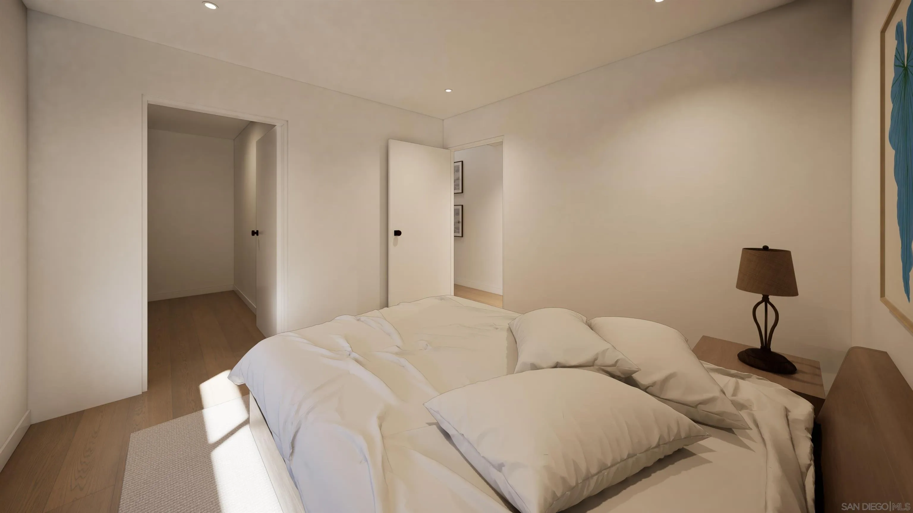 Bedroom with a low white bed, light wood floors, and sunlight across a woven rug.