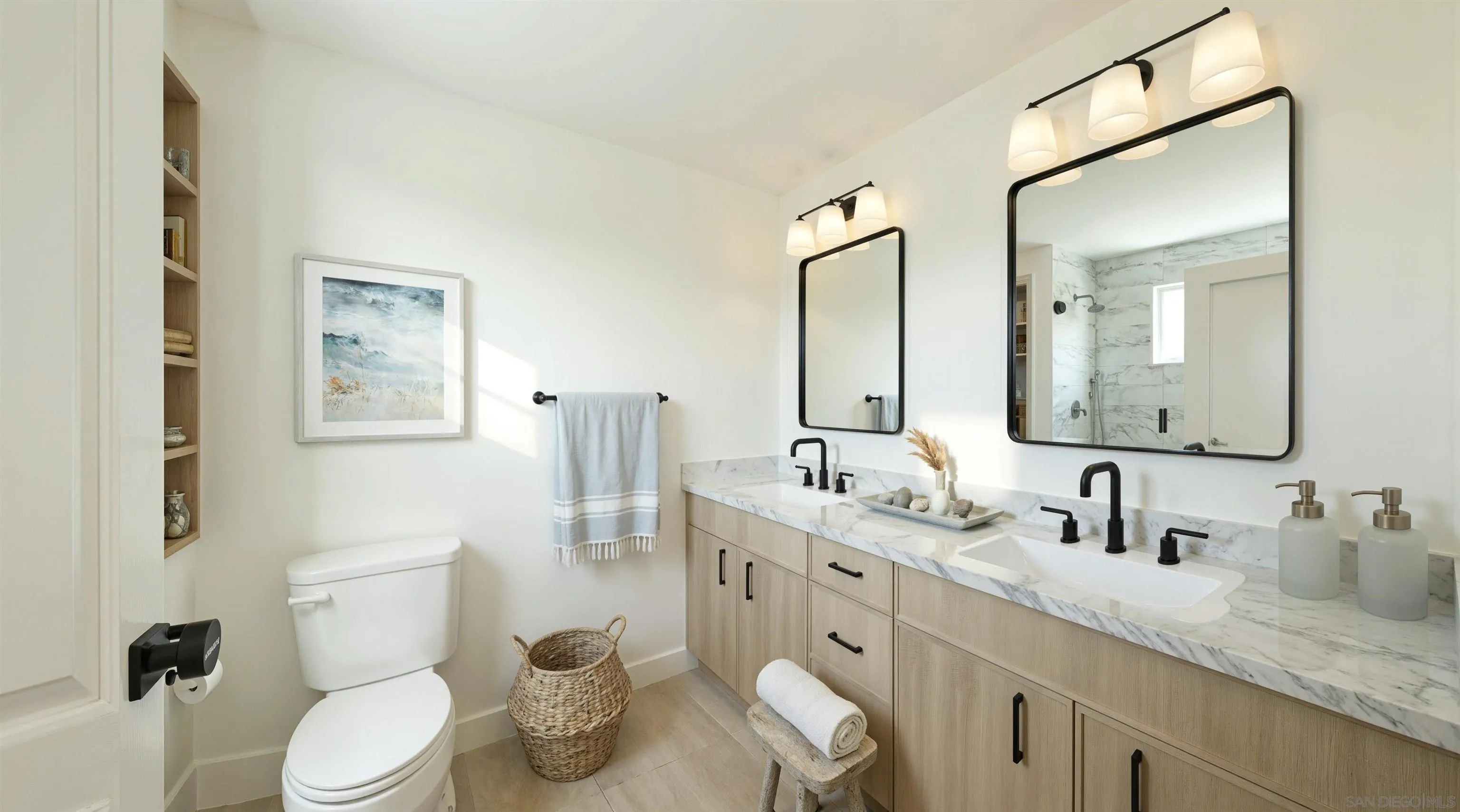 Bathroom with a marble double vanity, black fixtures, large mirrors, and a marble-tiled shower.