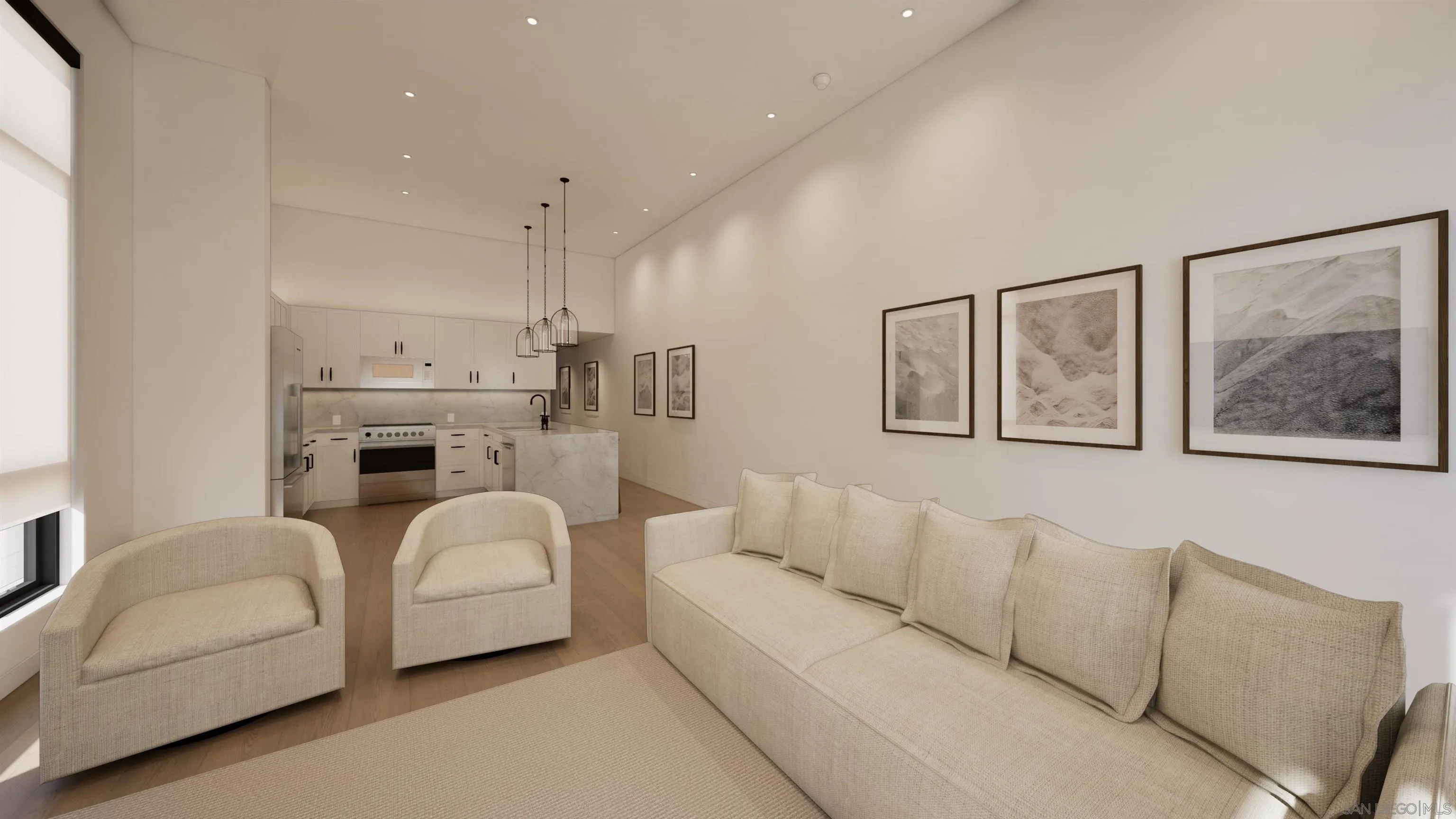 Open-plan living room with cream seating and framed art, adjoining a white kitchen with a marble peninsula.